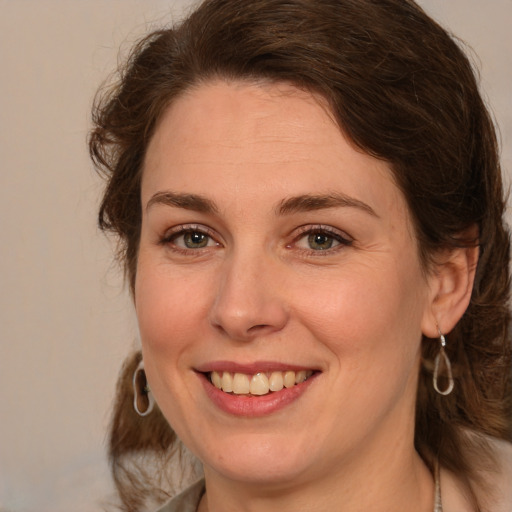 Joyful white young-adult female with medium  brown hair and green eyes