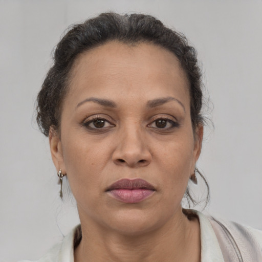 Joyful latino adult female with medium  brown hair and brown eyes