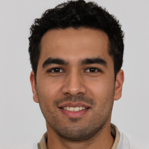 Joyful white young-adult male with short  black hair and brown eyes