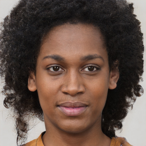 Joyful black young-adult female with long  brown hair and brown eyes