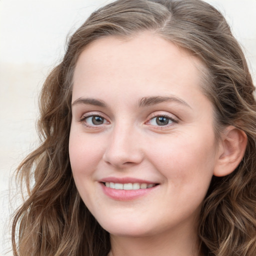 Joyful white young-adult female with long  brown hair and blue eyes