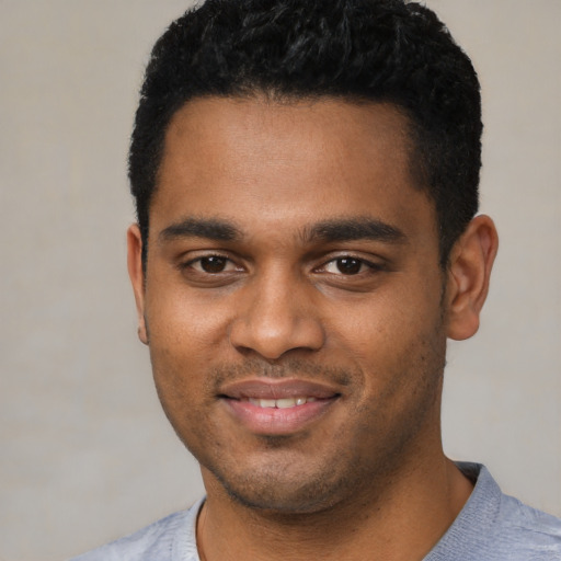 Joyful black young-adult male with short  black hair and brown eyes