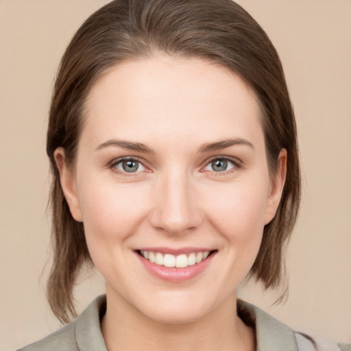 Joyful white young-adult female with medium  brown hair and grey eyes