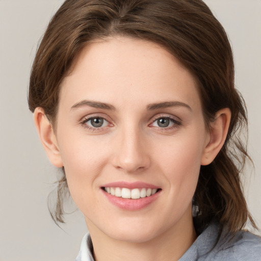 Joyful white young-adult female with medium  brown hair and grey eyes