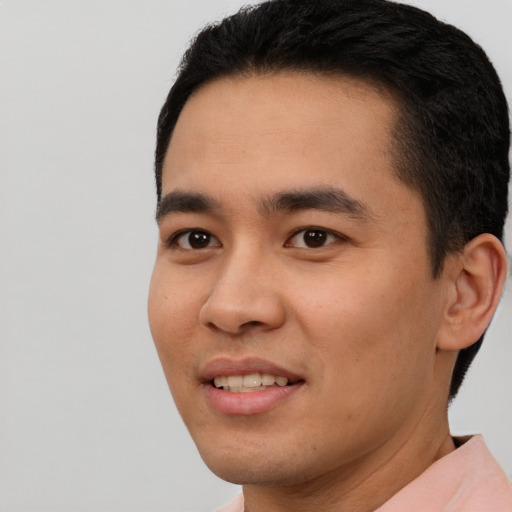 Joyful latino young-adult male with short  black hair and brown eyes