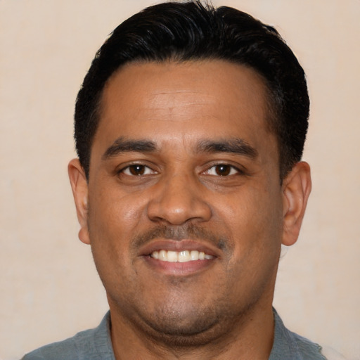 Joyful latino young-adult male with short  black hair and brown eyes