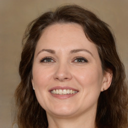 Joyful white adult female with long  brown hair and brown eyes