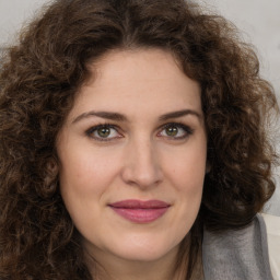 Joyful white young-adult female with long  brown hair and green eyes