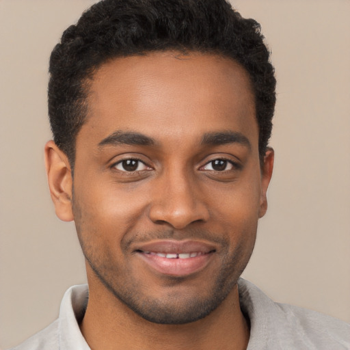 Joyful black young-adult male with short  brown hair and brown eyes