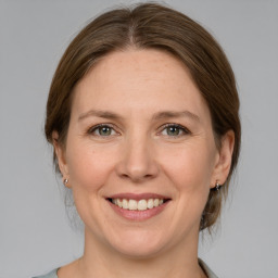 Joyful white adult female with medium  brown hair and grey eyes