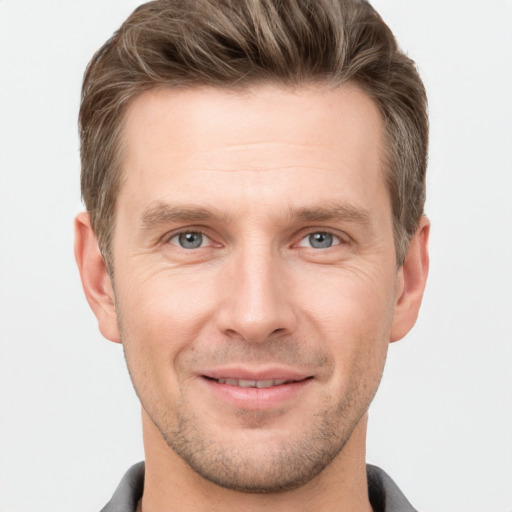 Joyful white young-adult male with short  brown hair and grey eyes