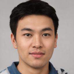 Joyful asian young-adult male with short  brown hair and brown eyes