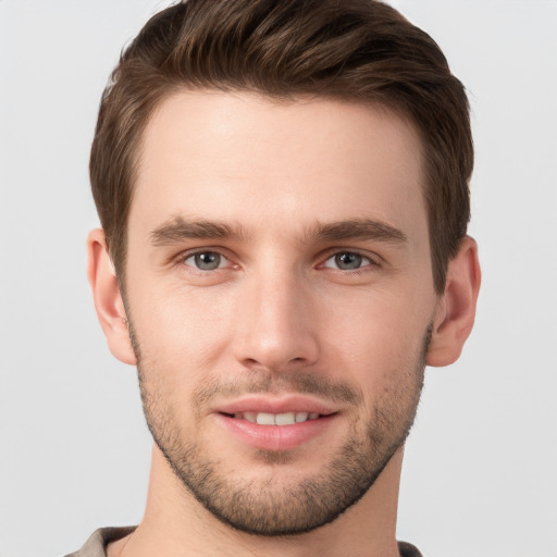 Joyful white young-adult male with short  brown hair and grey eyes