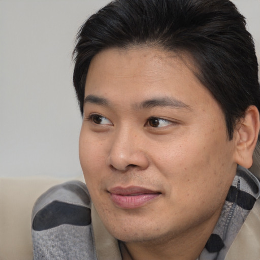 Joyful asian young-adult male with medium  brown hair and brown eyes