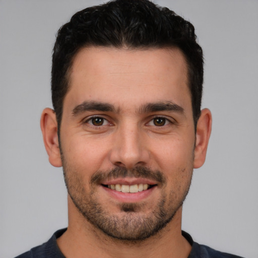 Joyful white young-adult male with short  black hair and brown eyes