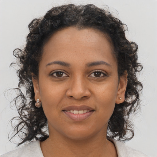 Joyful black young-adult female with medium  brown hair and brown eyes