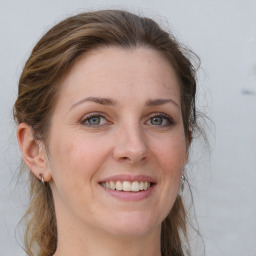 Joyful white young-adult female with long  brown hair and grey eyes