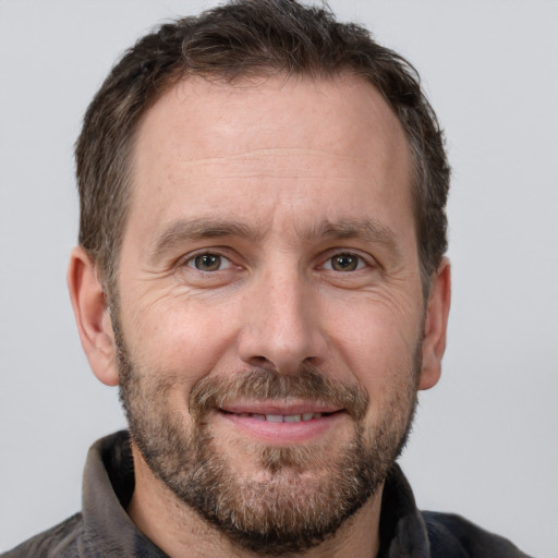 Joyful white adult male with short  brown hair and brown eyes