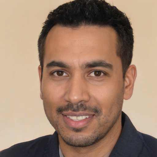 Joyful latino young-adult male with short  black hair and brown eyes
