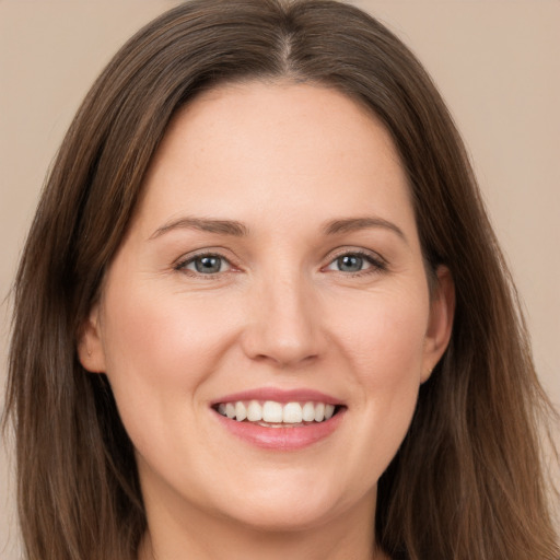 Joyful white young-adult female with long  brown hair and brown eyes