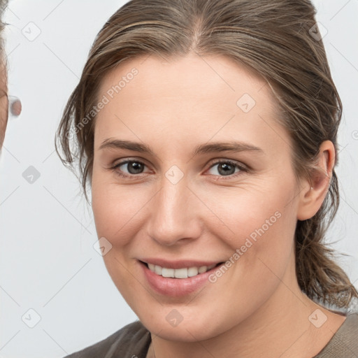 Joyful white young-adult female with medium  brown hair and grey eyes