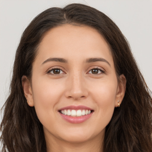 Joyful white young-adult female with long  brown hair and brown eyes