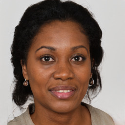 Joyful black adult female with medium  brown hair and brown eyes
