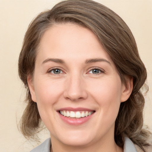 Joyful white young-adult female with medium  brown hair and green eyes