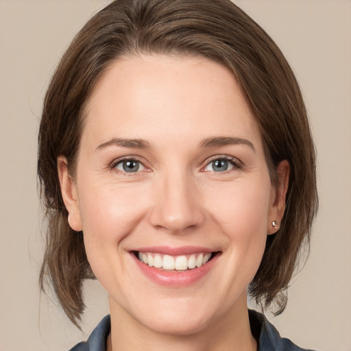 Joyful white young-adult female with medium  brown hair and grey eyes