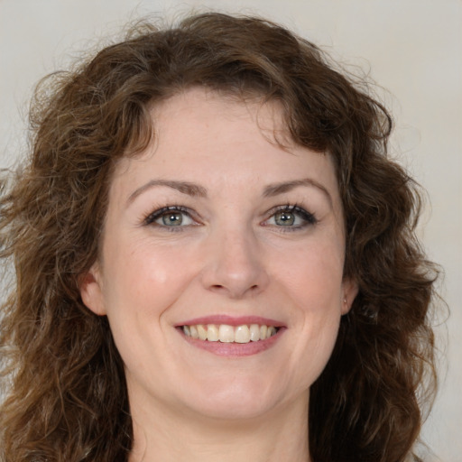 Joyful white young-adult female with medium  brown hair and green eyes