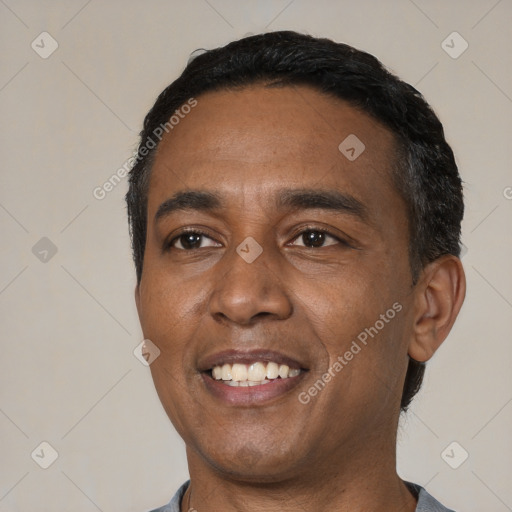 Joyful latino young-adult male with short  black hair and brown eyes