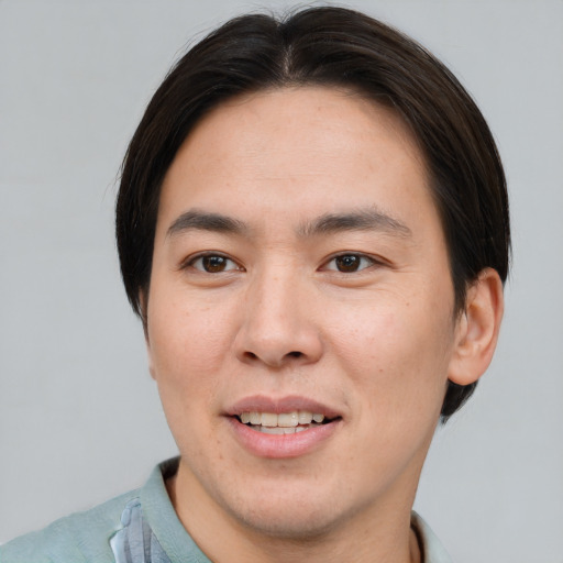 Joyful asian young-adult male with short  brown hair and brown eyes