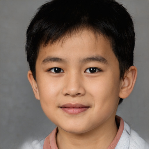 Joyful asian child male with short  brown hair and brown eyes
