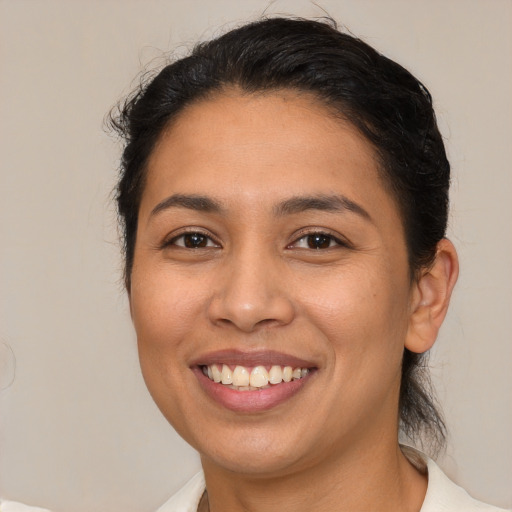 Joyful latino young-adult female with medium  brown hair and brown eyes