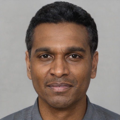 Joyful latino adult male with short  black hair and brown eyes