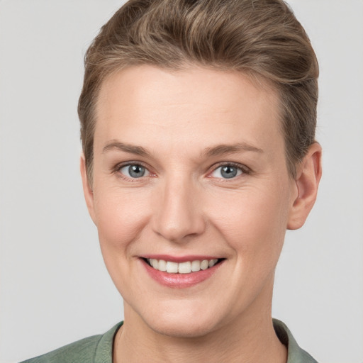 Joyful white young-adult female with short  brown hair and grey eyes