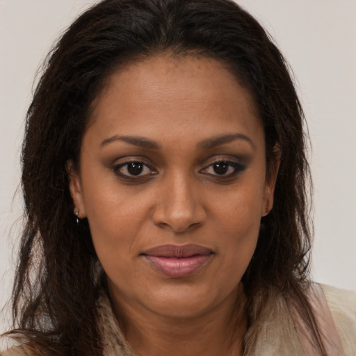 Joyful black young-adult female with long  brown hair and brown eyes
