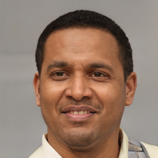 Joyful latino adult male with short  brown hair and brown eyes
