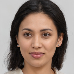 Joyful latino young-adult female with medium  brown hair and brown eyes