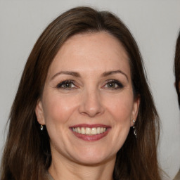 Joyful white adult female with long  brown hair and brown eyes