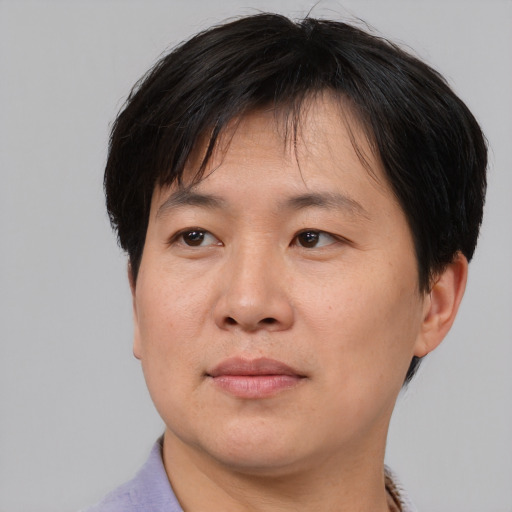 Joyful asian adult male with short  brown hair and brown eyes