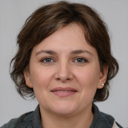 Joyful white adult female with medium  brown hair and brown eyes