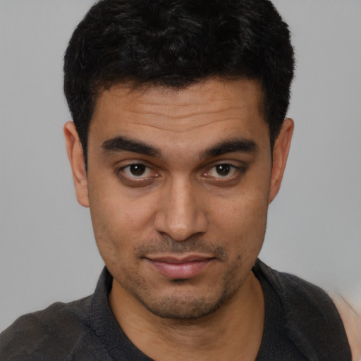 Joyful latino young-adult male with short  black hair and brown eyes