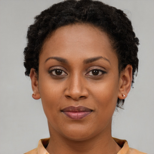 Joyful black young-adult female with short  brown hair and brown eyes