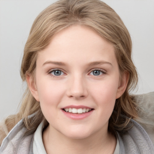 Joyful white child female with medium  brown hair and grey eyes