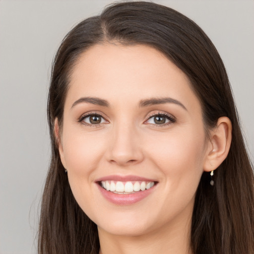 Joyful white young-adult female with long  brown hair and brown eyes