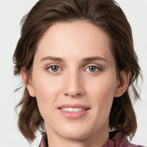 Joyful white young-adult female with medium  brown hair and green eyes