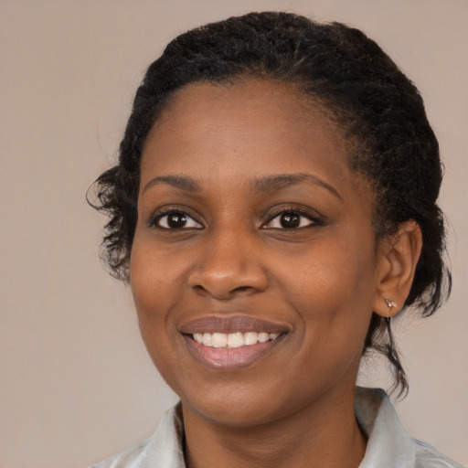 Joyful black young-adult female with medium  brown hair and brown eyes