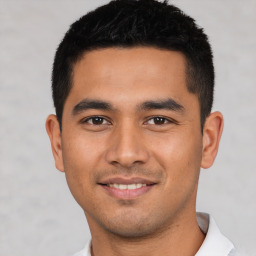 Joyful latino young-adult male with short  black hair and brown eyes