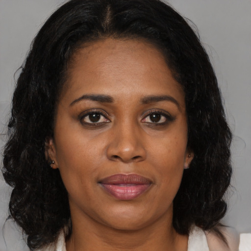 Joyful black adult female with medium  brown hair and brown eyes